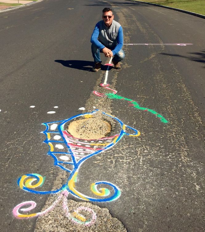 Cr Spooner with a couple of the Shire's higher profile potholes in Lawson Street, Byron Bay. Photo: Supplied.